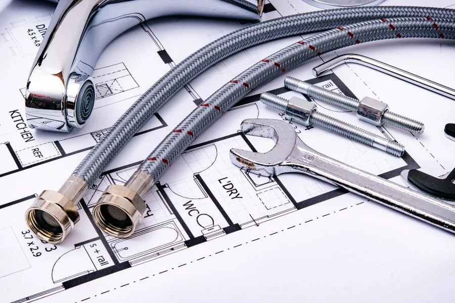Plumbing tools and supply hoses on a floor plan